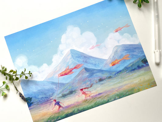 An art print of the Carefree illustration lays on a white table. There are touches of green leaves around the edges. A white pen sits beside the art print to show the size.