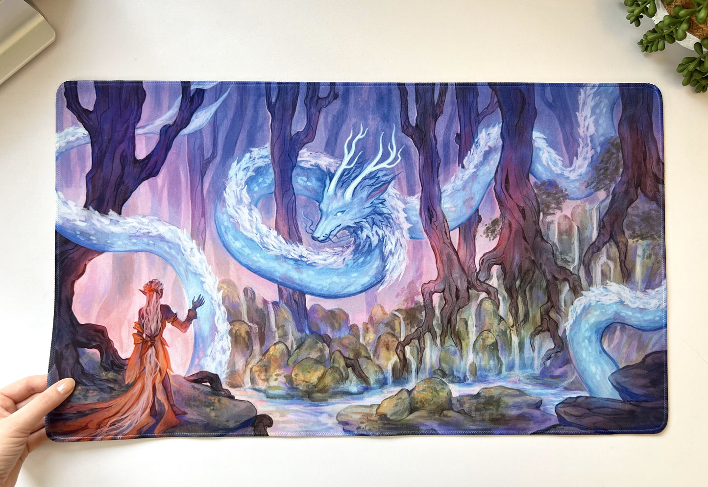 A female elf dressed in pale orange receives her magic from her clan's guardian dragon, a long silver serpent with horns that weaves through the trees.